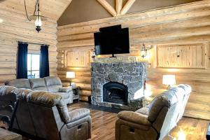 a living room with couches and a stone fireplace at Poppy's Place Main House in South Fork