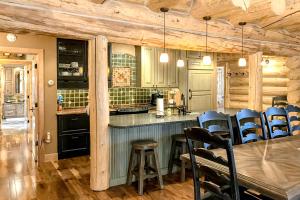 a kitchen with a bar and a table and chairs at Poppy's Place Main House in South Fork