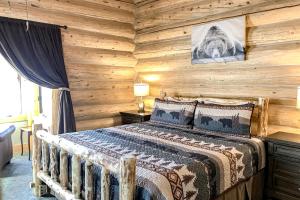 ein Schlafzimmer mit einem Bett in einer Holzwand in der Unterkunft Poppy's Place Main House in South Fork