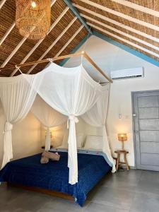een slaapkamer met een hemelbed in een kamer bij Captain Goodtimes in Gili Air