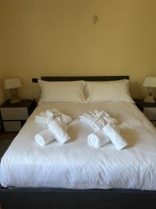 Villa Fiore Luxury Pool & Garden في بيزا: زوجان من الجوارب البيضاء على سرير