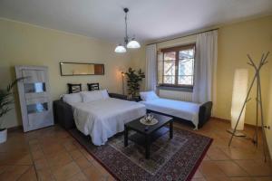 a bedroom with two beds and a couch and a table at Villa Fiore Luxury Pool & Garden in Pisa