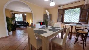 una sala da pranzo e un soggiorno con tavolo e sedie. di Villa Fiore Luxury Pool & Garden a Pisa