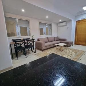 a living room with a couch and a table at Spacious Apartment Ennasr 2 in Ariana