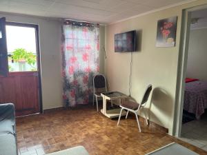 a room with two chairs and a table and a window at Carola's Garden in Willemstad