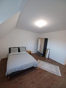 ein Schlafzimmer mit einem Bett in einem weißen Raum in der Unterkunft Maison neuf pour 4 personnes 85m2 in Montlouis-sur-Loire