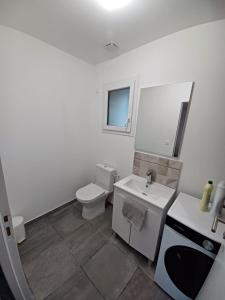 ein weißes Badezimmer mit Toilette und Waschbecken in der Unterkunft Maison neuf pour 4 personnes 85m2 in Montlouis-sur-Loire + 5 Fotos