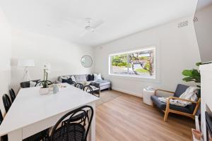 a kitchen and living room with a table and chairs at Little Manly 3 Bedroom Sanctuary in Sydney