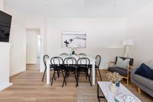 a white living room with a dining room table and chairs at Little Manly 3 Bedroom Sanctuary in Sydney