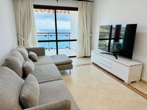 a living room with a couch and a flat screen tv at APARTMENT WITH OCEAN VIEW in Playa del Cura
