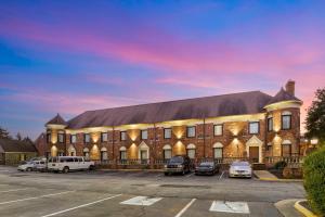 a large brick building with cars parked in a parking lot at Best Western PLUS Governor's Inn Richmond in Midlothian