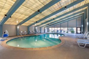 - une grande piscine dans un grand bâtiment avec des chaises dans l'établissement Best Western Plus New Englander, à Woburn