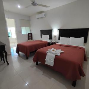 Cette chambre d'hôtel comprend 2 lits avec des draps rouges. dans l'établissement Hotel Malecón, à Campeche