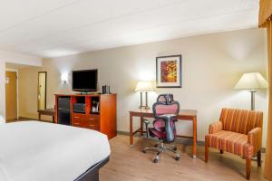 a hotel room with a bed and a desk and a chair at Best Western PLUS Governor's Inn Richmond in Midlothian