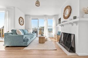een woonkamer met een blauwe bank en een open haard bij Shore to Adore: Ocean Views & WiFi in Lulworth