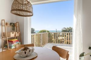 een kamer met een tafel en een balkon met uitzicht bij Shore to Adore: Ocean Views & WiFi in Lulworth