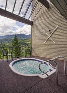 a hot tub with a clock on the side of a building at Amazing Views 2 BR/2 BA Ski In Ski Out Condo in Whistler