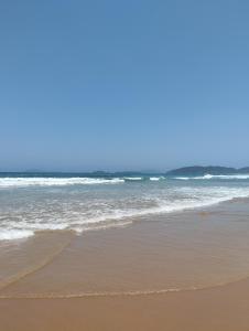 einen Sandstrand mit Wellen im Ozean in der Unterkunft Flat para 4 pessoas bem pertinho da praia de Geriba in Búzios