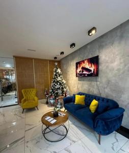 sala de estar con sofá azul y árbol de Navidad en Apartman Zlatibor Renome, en Zlatibor