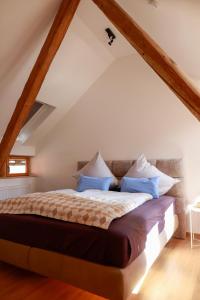 a bedroom with a large bed with blue pillows at Neu - Wenkheimer Hof Scheunen-Loft in Iphofen
