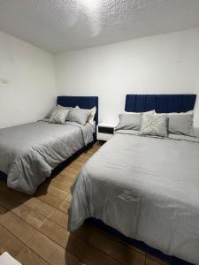 duas camas sentadas uma ao lado da outra num quarto em APARTAMENTO PRIVADO cerca al aeropuerto em Bogotá