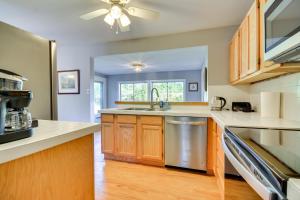 a kitchen with wooden cabinets and a stainless steel dishwasher at Laptop-Friendly Greensboro Home with Fireplace! in Greensboro
