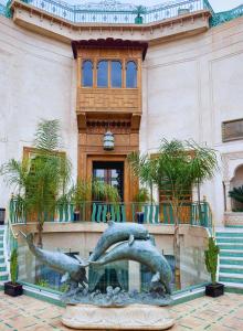Sillage Palace Sky & Spa في مراكش: تمثال دلفين امام مبنى