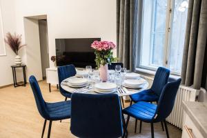 a dining room with a table and blue chairs at CracWoW K8 No.6 Apartment in Krakow
