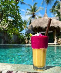 a drink sitting on a table next to a pool at Captain Coconuts Gili Air in Gili Air