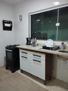 a kitchen with a stove and a white counter top at Flat para 4 pessoas bem pertinho da praia de Geriba in Búzios