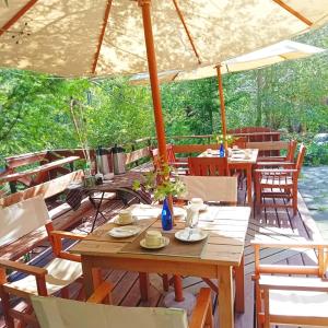 a wooden table and chairs under an umbrella at La Cabaña de Piedra in Las Trancas
