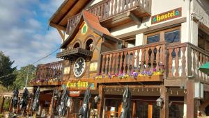 a large wooden building with a clock on it at Cucu Haus Hostel in La Cumbrecita