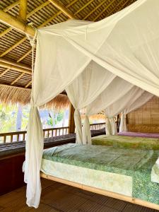 a bed in a tent with a mosquito net at Captain Coconuts Gili Air in Gili Islands