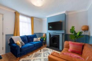 a living room with a blue couch and a tv at Cosy 2-bedroom house in Croydon in Croydon