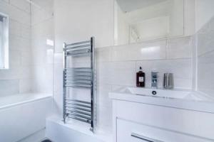 a white bathroom with a sink and a shower at Cosy 2-bedroom house in Croydon in Croydon