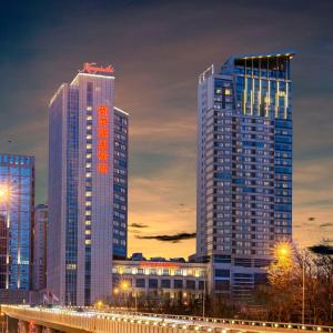 two tall skyscrapers in a city at night at Kempinski Hotel Dalian in Dalian