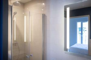 een badkamer met een douche en een glazen deur bij Best Western 11BAUER Paris Saint-Ouen in Saint-Ouen