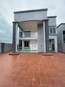 a large house with a large patio in front of it at Elegant and Cosy Four Bedroom Home in Accra in Accra