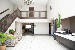 an office lobby with a staircase and chairs at SureStay Plus by Best Western Montrose in Montrose