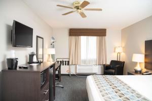 a hotel room with a bed and a flat screen tv at SureStay Plus by Best Western Montrose in Montrose