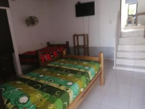 a bedroom with a bed with a comforter on it at Casa lowcost relajación in La Dorada