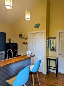 una cocina con una barra con 2 sillas azules en West Bay Roatan - Sunny & Modern Oasis- 2 Bedrooms - 3 min walk to beach, en Roatan