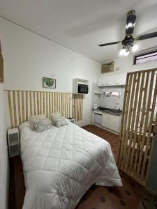 1 dormitorio con 1 cama blanca grande y cocina en HOME espacios 1 en Santa Fe