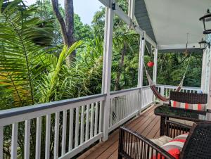 a porch with a hammock and trees at West Bay Roatan - Sunny & Modern Oasis- 2 Bedrooms - 3 min walk to beach in Roatán