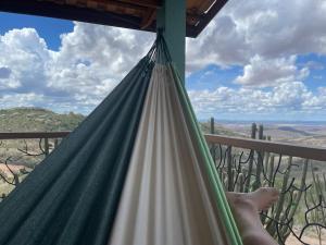 蒙蒂達斯加梅萊拉斯的住宿－Chalé romântico, com vista panorâmica, para Casais，躺在吊床上俯瞰沙漠的人