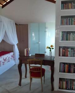 a bedroom with a desk with a chair and a bed at Chalé romântico, com vista panorâmica, para Casais in Monte das Gameleiras