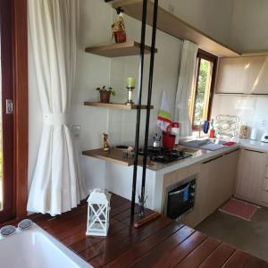 uma cozinha com um fogão e uma banheira num quarto em Chalé romântico, com vista panorâmica, para Casais em Monte das Gameleiras