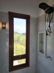 een raam in een badkamer met uitzicht op een veld bij Chalé romântico, com vista panorâmica, para Casais in Monte das Gameleiras