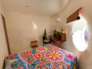 een slaapkamer met een bed en een bureau in een kamer bij Casa ecológica surf e natureza in Camassari