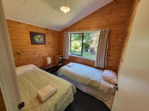 2 Betten in einem Zimmer mit Fenster in der Unterkunft Off The Beaten Trail Acc & Bike Tours in Murchison